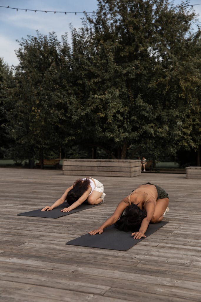 Faceless women practicing Extended Childs pose in nature
